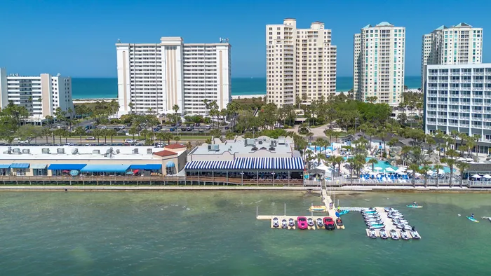 Vibrant waterfront cityscape with high-rise apartments overlooking a scenic coastal view, offering luxury living by the sea.