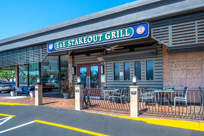 Inviting exterior of E&E Stakeout Grill with spacious outdoor seating and stylish decor.