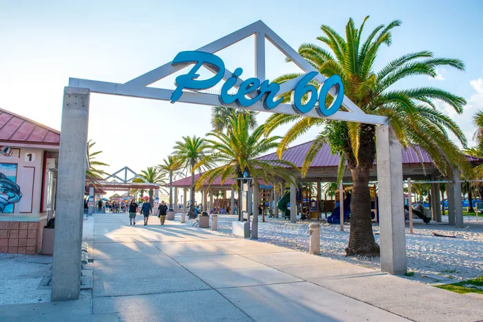 Sunlit Pier 60 entrance showcasing a lively boardwalk with palm trees and vibrant beach vibes.