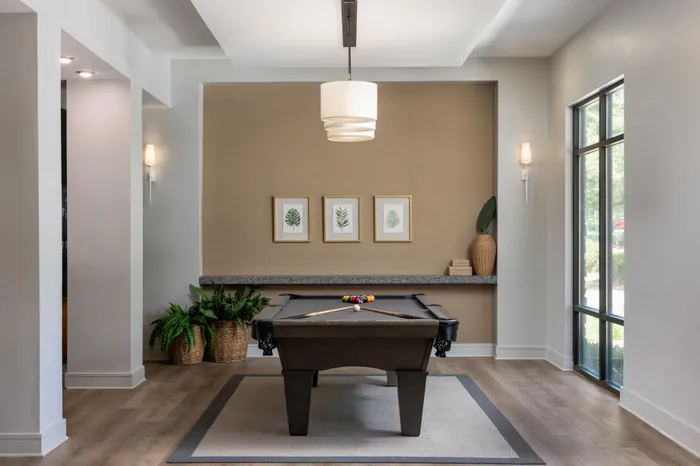Lounge at Lantower Waverly with plush seating and modern chandeliers and décor and a billiard table.