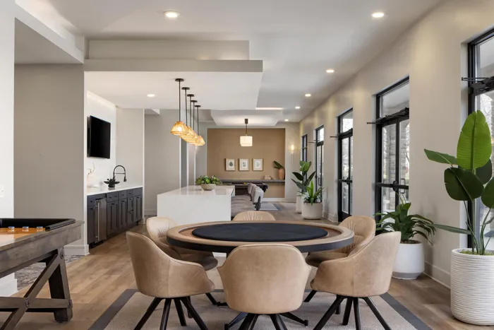 Lounge at Lantower Waverly with plush seating and modern chandeliers and décor and a foosball table.