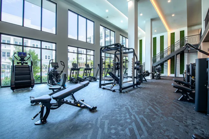 Modern fitness center with large windows, state-of-the-art gym equipment, and an inviting ambiance for a complete workout experience.