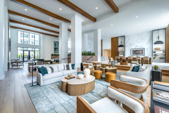 Elegant and spacious modern lounge with high ceilings, stylish seating, and natural light. Features contemporary decor and plush furnishings for a luxurious living experience.