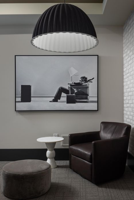 Elegant reading nook with a plush leather chair, modern art, and ambient lighting in a chic apartment.