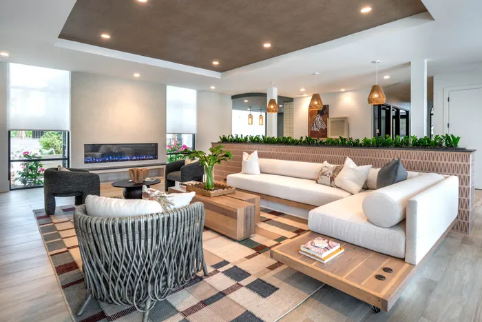 Sophisticated open-concept living space with contemporary furniture, elegant fireplace, and ambient lighting.