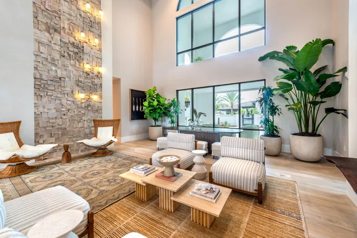 Elegant living room with high ceilings, modern design, and lush indoor plants featuring stylish seating and natural light.