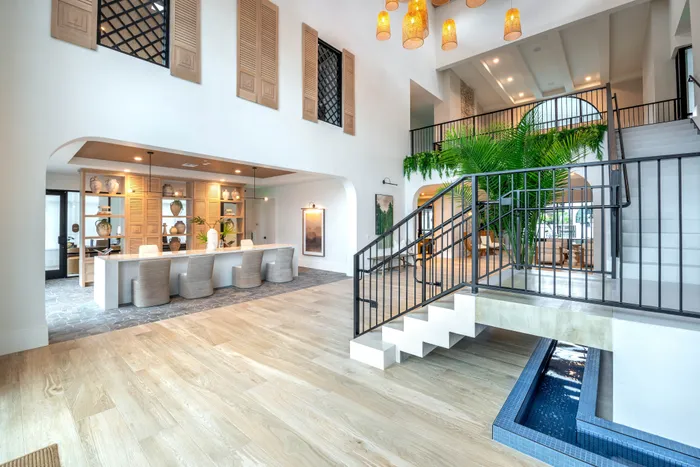 Luxurious apartment interior showcasing a modern open-plan design with an inviting wooden floor, elegant staircase, and stylish decor.