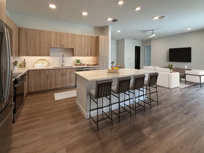 Luxurious open-concept kitchen and living area with modern appliances, stylish cabinetry, and a spacious island with seating.