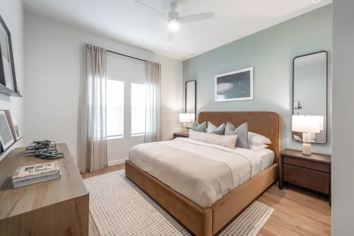 Bright and inviting bedroom with stylish decor, featuring a large cozy bed, elegant wooden furniture, and soft natural light from the window.