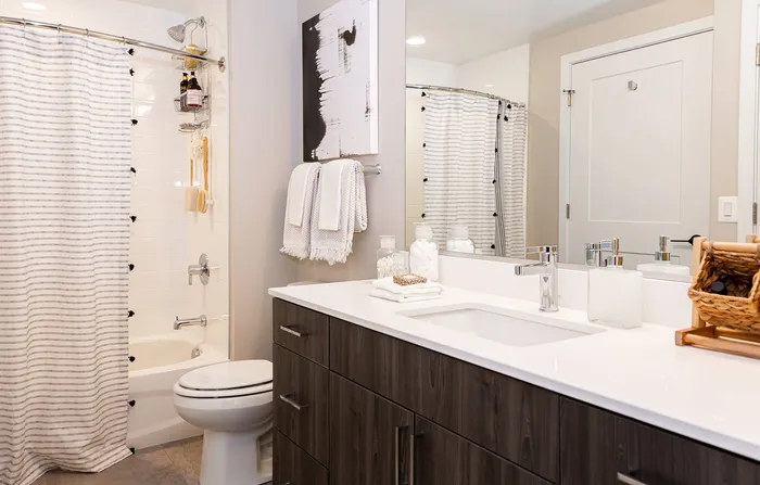Bathroom with Ceramic Wall Surrounds Tile Flooring, and a Quartz Counter Top.