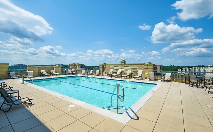 Relax at the rooftop swimming pool with two marked lap lanes and expansive sundeck at Meridian at Grosvenor Station, offering a luxury outdoor oasis with panoramic views of North Bethesda and easy access to the nearby Grosvenor-Strathmore | Luxury North Bethesda MD Apartments | Luxury Rockville Apartments
