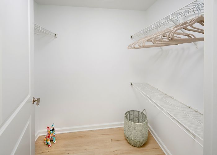Ellington One Bedroom walk-in closet featuring new wood-style vinyl plank flooring | Meridian at Grosvenor Station | Luxury North Bethesda MD Apartments | Luxury Rockville MD Apartments