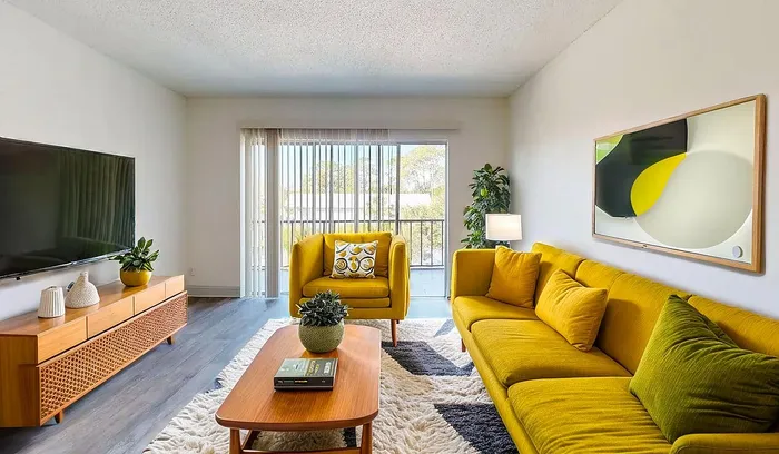 Modern living room with vibrant yellow seating, stylish wood furniture, and large window for natural light.
