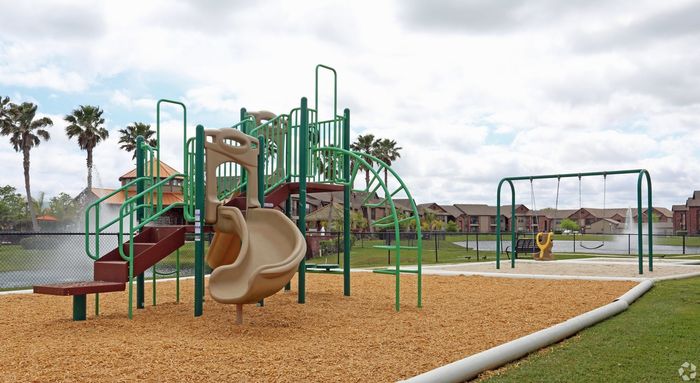 Vibrant community playground with slide and swing set under sunny skies.