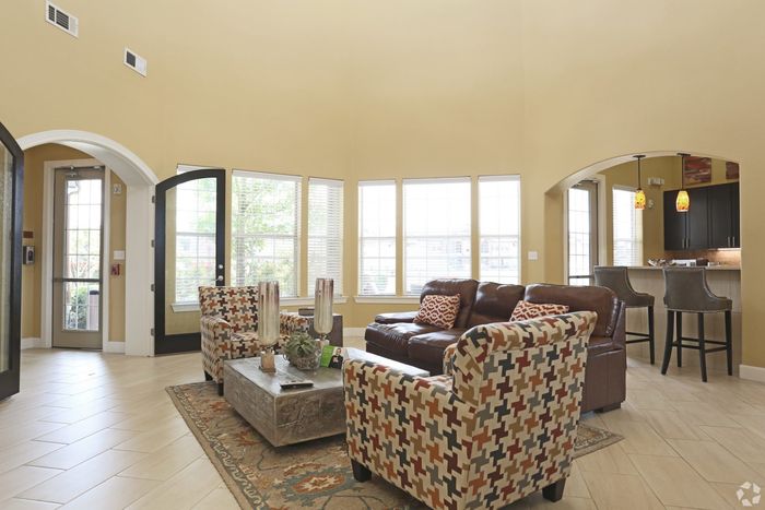 Spacious clubhouse with large windows, stylish furniture, and an open kitchen bar.