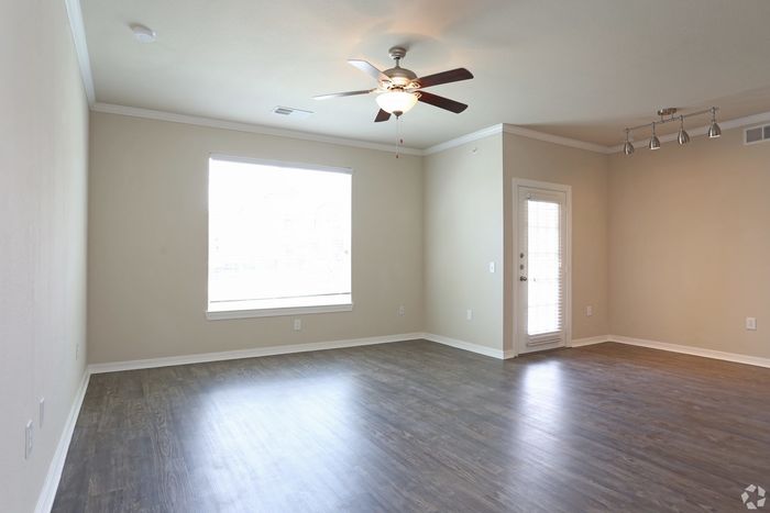 Spacious and bright living room with modern hardwood flooring and elegant ceiling fan