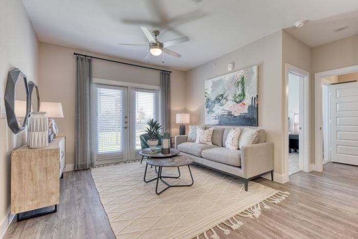 Inviting living room with a modern gray sofa, elegant wall art, and stylish decor, perfect for relaxing and entertaining.