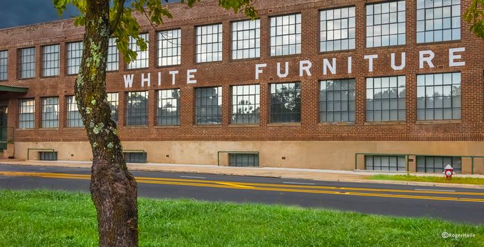 Charming brick building exterior with large windows, showcasing historical architecture in a serene neighborhood.