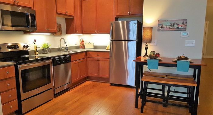 Cozy kitchen with stainless steel appliances, rich wooden cabinets, and elegant dining nook.