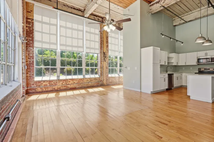 Chic industrial loft with exposed brick, large windows, and a modern open kitchen. This bright, airy space combines vintage charm with contemporary comfort.