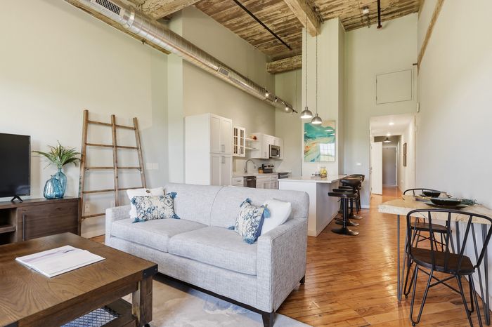 Chic urban apartment with open layout, featuring a stylish kitchen, cozy living area, and sleek industrial design elements.