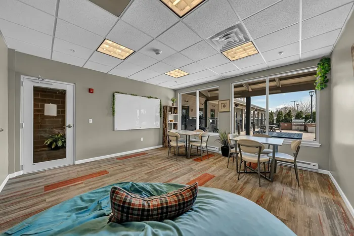 Bright and inviting community study room and work room with modern decor, comfortable seating, and large windows offering impressive outdoor views.