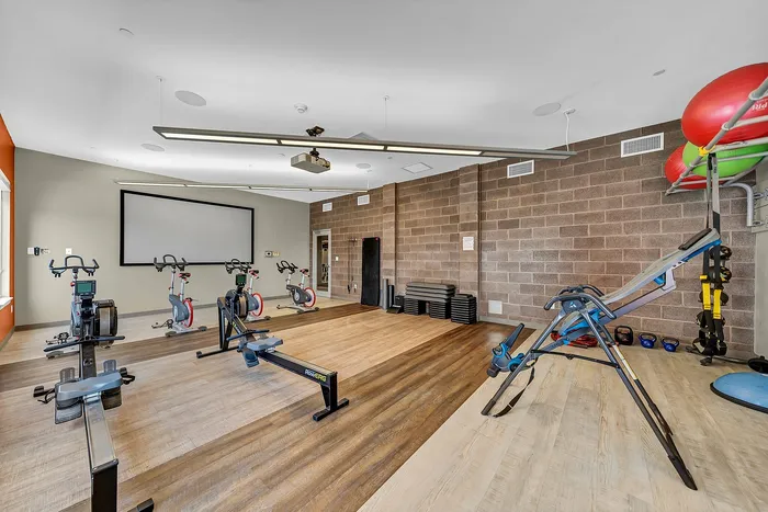 Yoga studio featuring state-of-the-art exercise bikes, rowing machines, and balance balls, perfect for a dynamic workout experience for apartment residents.