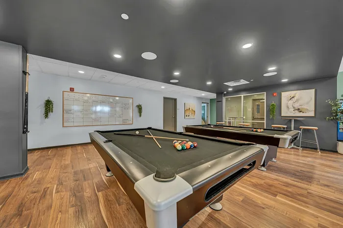 Chic game room with pool tables and stylish modern decor.