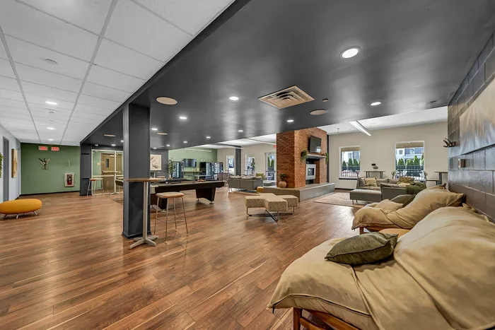 Luxurious communal lounge with sleek hardwood floors, contemporary seating, gas fire places, pool tables, perfect for social gatherings and relaxation.