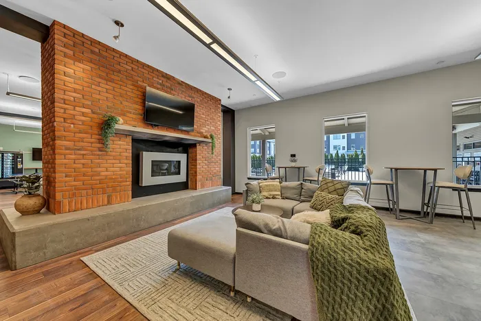 Chic living area with a modern brick fireplace, plush seating, and cozy ambiance perfect for relaxation and entertaining.
