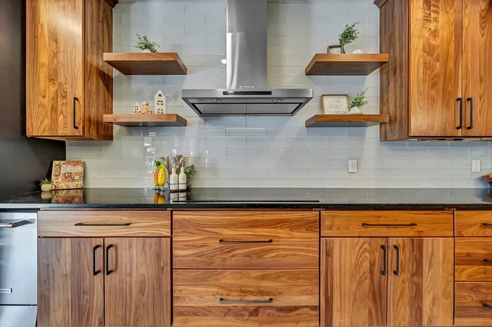 Chic kitchen for luxury apartment living with warm wooden cabinets, open shelving, and sleek stainless steel range hood enhancing modern design.