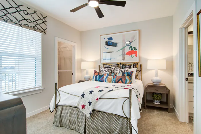 Three-Bedroom Apartments in Sugar Hill, GA - Cadence Sugar Hill - Bedroom with Ceiling Fan, Carpet Flooring, Large Window, Oversized Closet, and En-Suite Bathroom