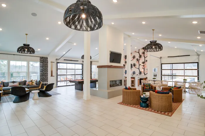 Sugar Hill, GA Apartments Near Mall of Georgia - Cadence Sugar Hill - Clubhouse with High Ceilings, Fireplace, Pool Table and Lounge Seating