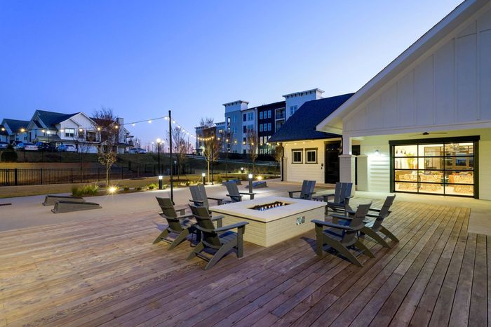 Apartments For Rent In Sugar Hill GA - Fire Pit With Lounge Chairs, Wood-Style Flooring, View Of The Clubhouse.