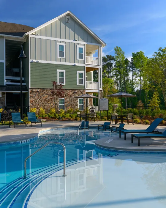Apartments in Athens, GA For Rent - Lullwater At Jennings - Resort-Style Pool With Expansive Sundeck, Pool Lounge Chairs, Tables And Chairs With Umbrellas, And Lush Landscaping.