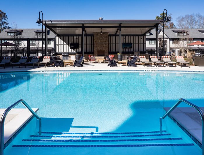 Pet-Friendly Apartments in Gainesville, GA - The Mill at New Holland - Swimming Pool with Lounge Chairs, Covered Seating Area, and BBQ Area