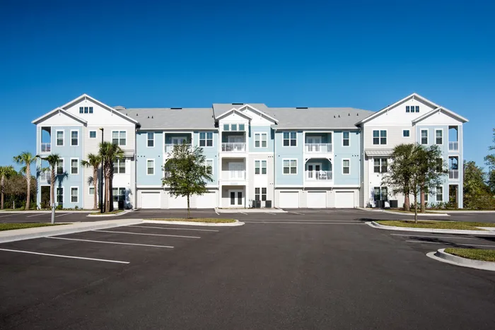 apartment building exterior and parking lot on sunny day