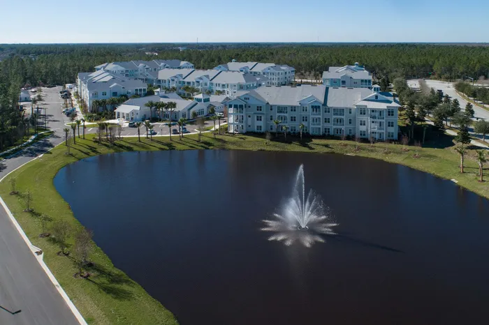 aerial view of apartment buildings and lake on sunny day