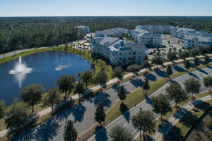 aerial shot of apartment buildings, lake and roadway