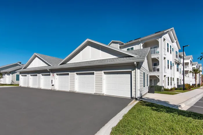 detached garages and apartment building in background on sunny day