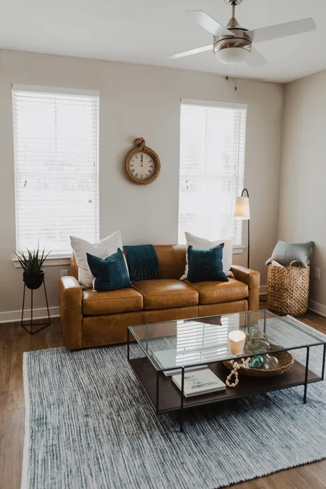 living room with leather couch and windows