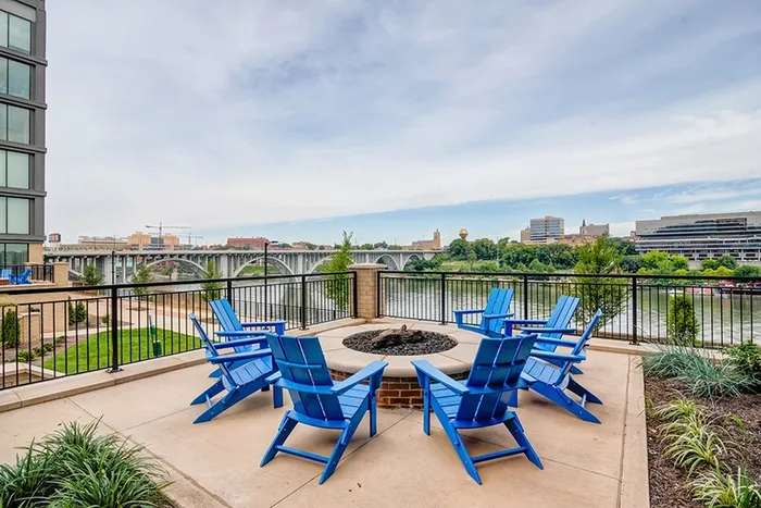 Outdoor fireplace with Airadonaks chairs overlooking river