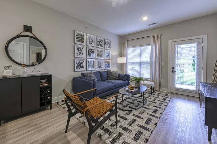 Raymore, MO Apartments - Encore - Living Room with Wood-Style Floors and Private Patio Access