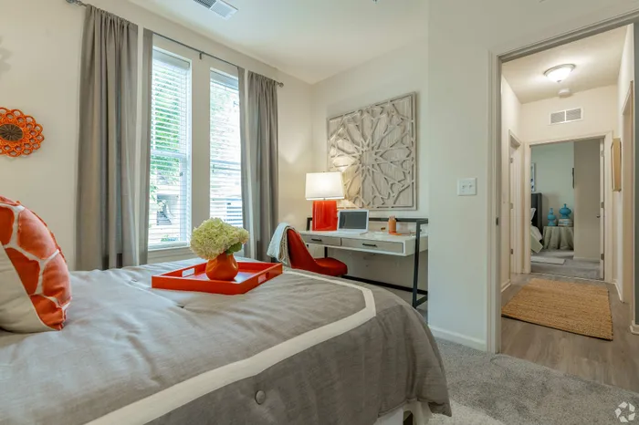Elegant bedroom with a desk area, natural light, and modern decor.