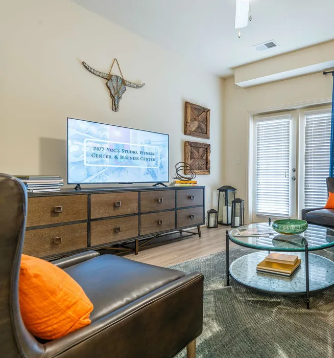 Chic living room with modern furnishings, featuring a stylish TV setup and cozy seating.