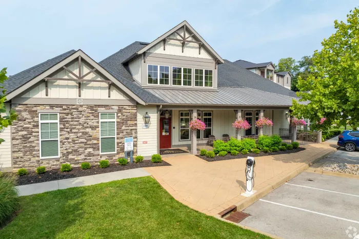 Quaint residential building with stone facade, lush landscaping, and inviting porch.