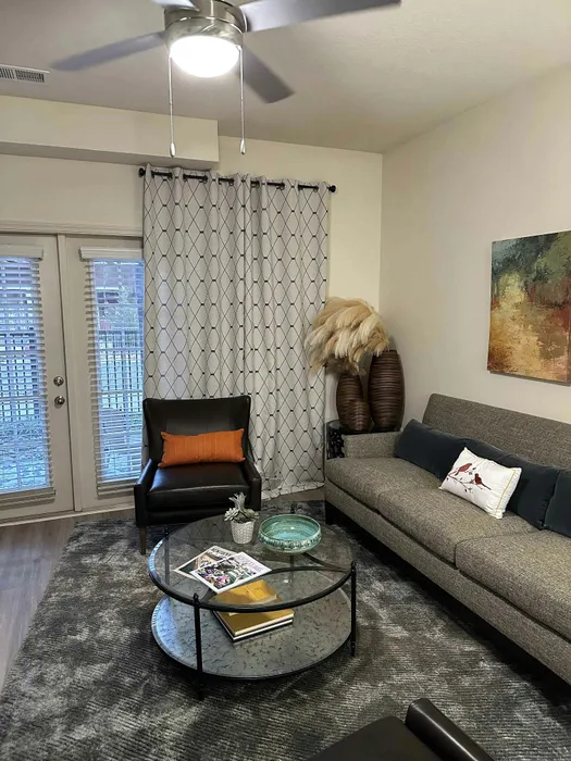 Inviting living room with elegant decor, featuring a stylish sofa, a sleek glass coffee table, and contemporary accents.