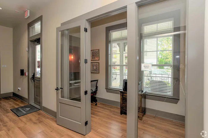 Modern business center with glass doors, warm lighting, and wooden flooring.