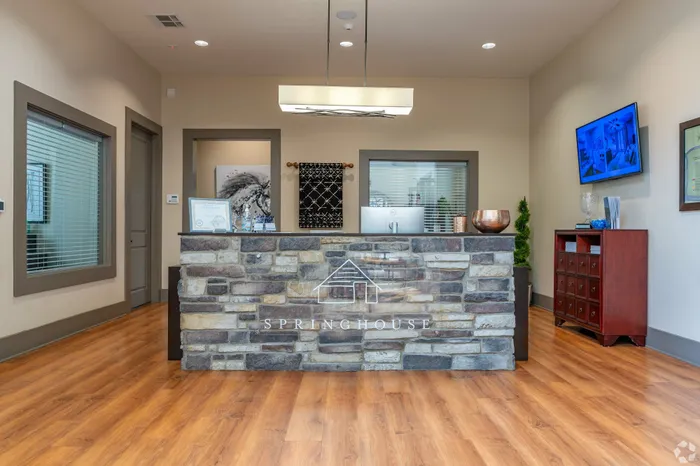 Inviting reception area with a rustic stone desk and modern decor elements.