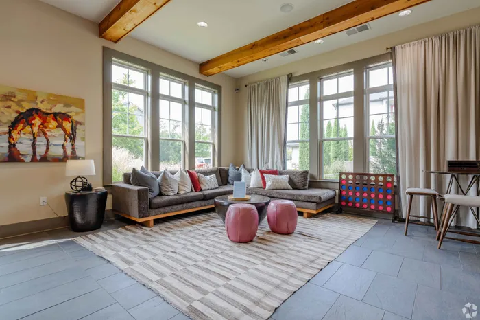 Bright living room featuring a sectional sofa, large windows, and modern decor.